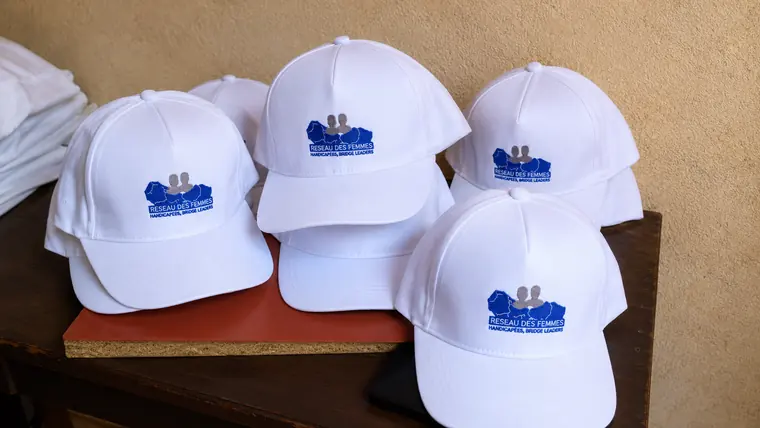 Série de casquettes blanches brodées pour le Réseau des Femmes Handicapées