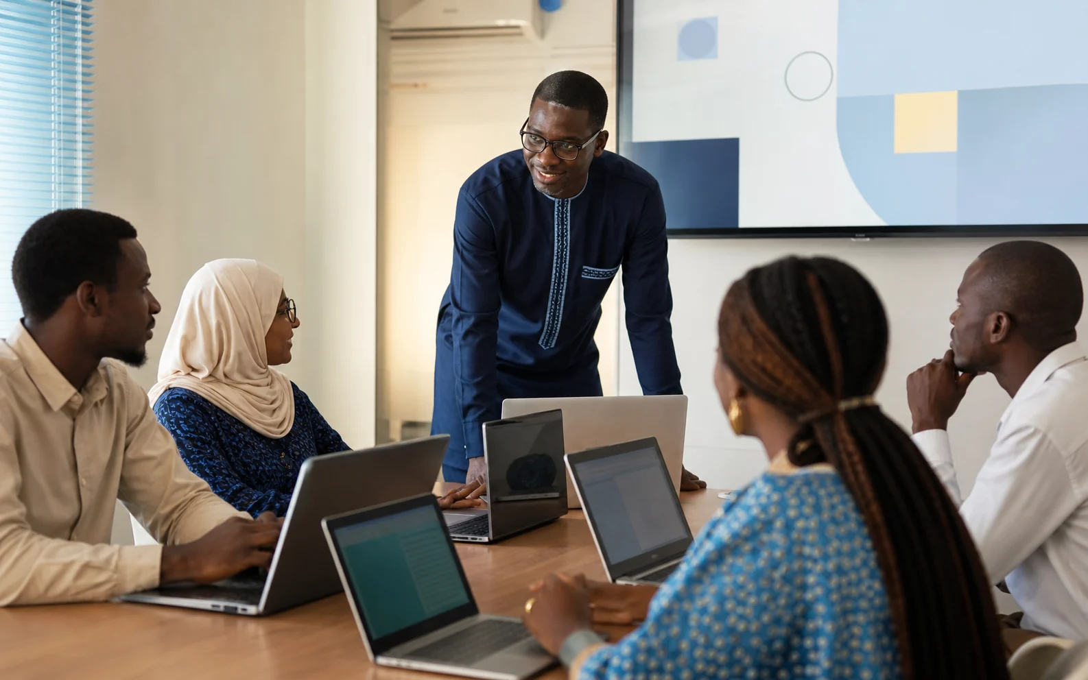 Formateur accompagnant un groupe d'adultes sur ordinateur